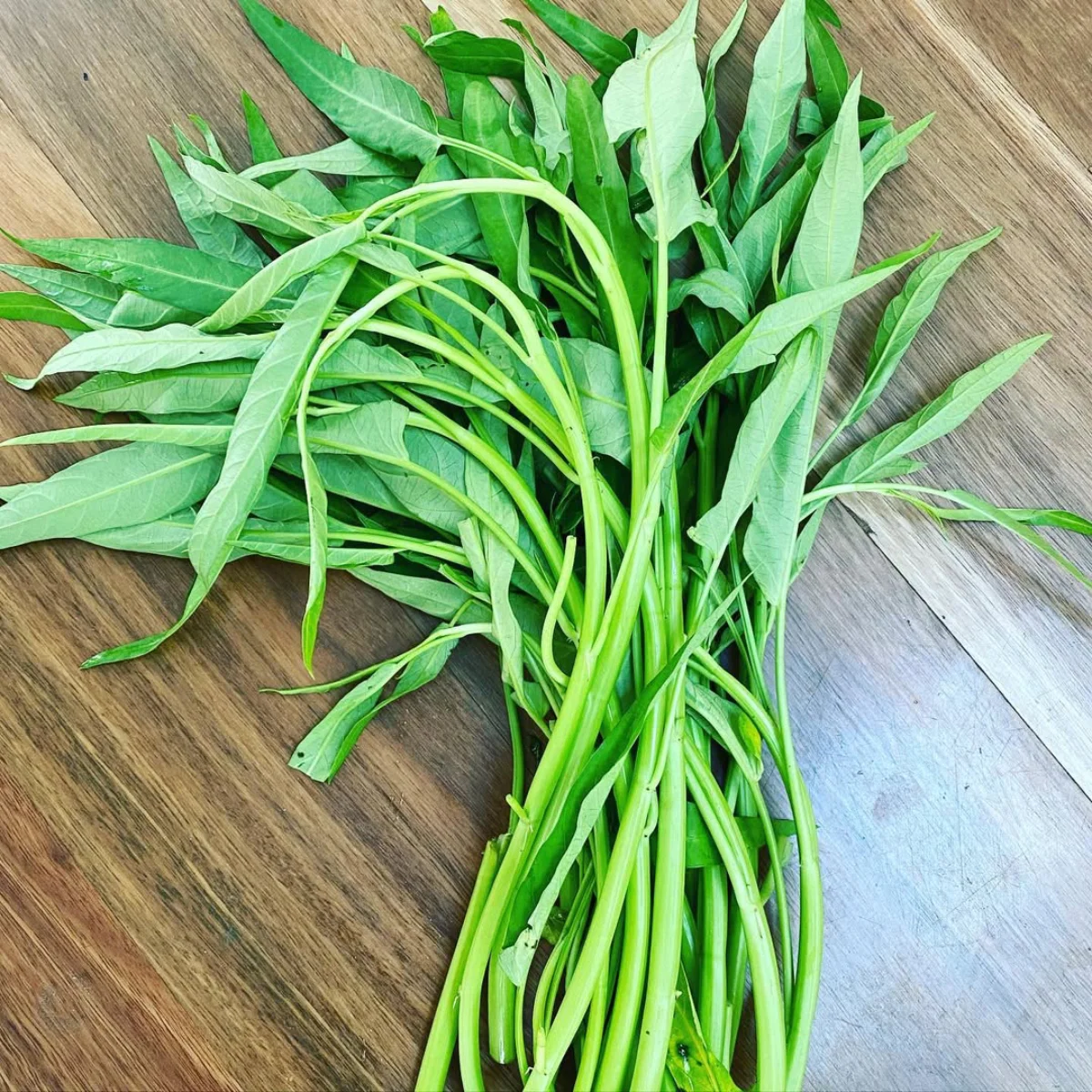 Kangkung di atas meja kayu.